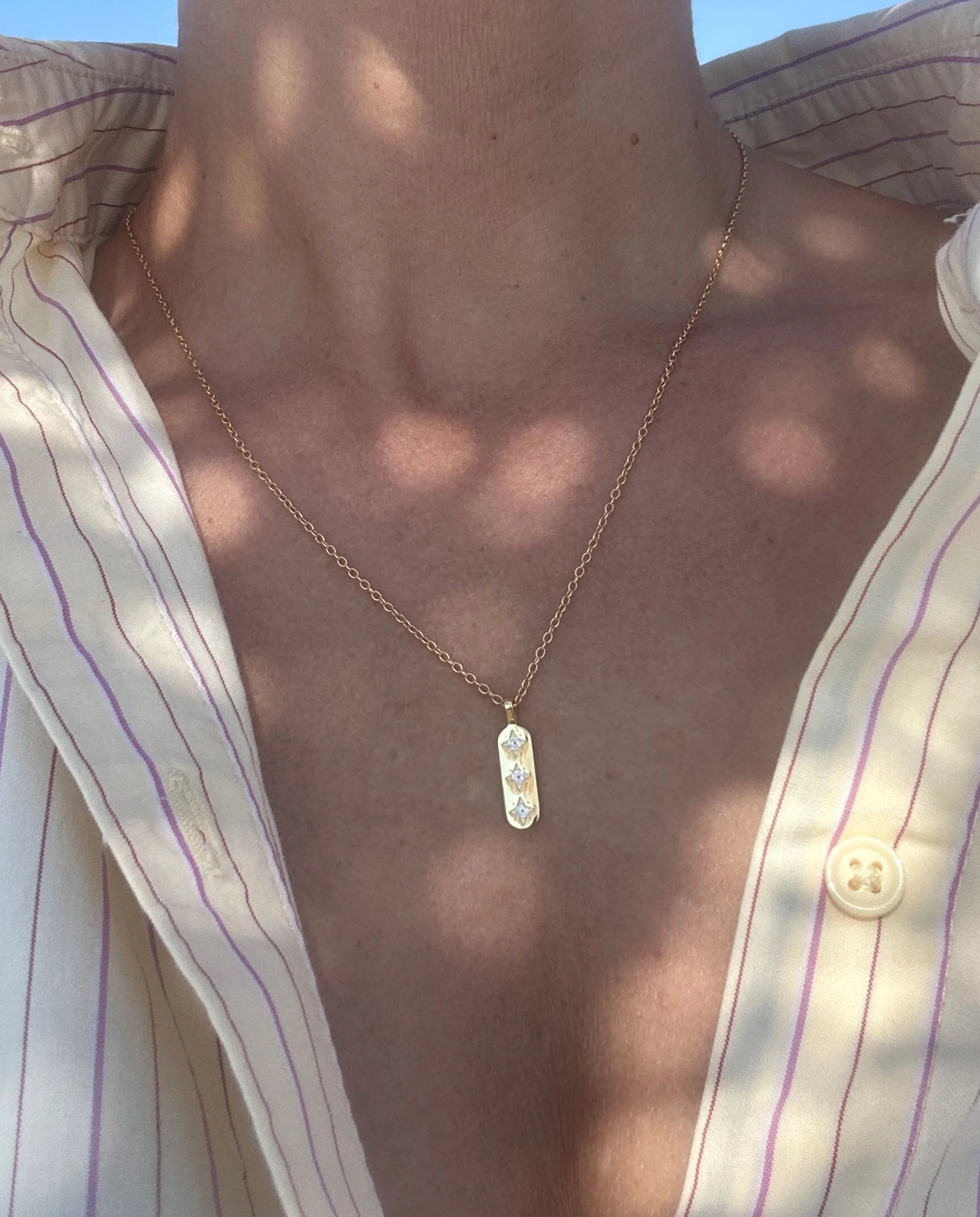 Close up of the Guiding Light Gold Pendant Necklace by Frequency Paris-Ibiza. A delicate pendant, perfect for every outfit. 