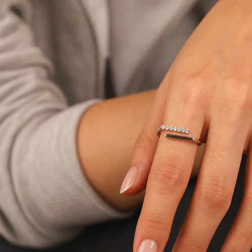 Frequency Paris-Ibiza Cosmic Trust Ring in gold worn on a model, showing adjustable open band with one clean gold band and one zircon crystal encrusted band, minimal contemporary design
