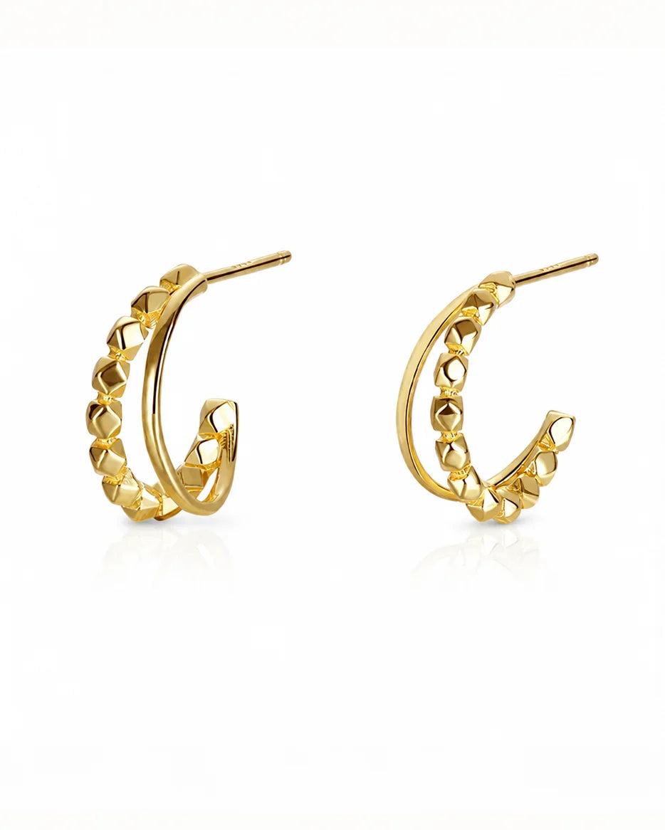 Close-up of Frequency Paris-Ibiza Divine Feminine Gold Hoop Earrings. 18K gold-plated sterling silver with one textured hoop and one smooth delicate hoop, two hoops in one design, shown on a white background.