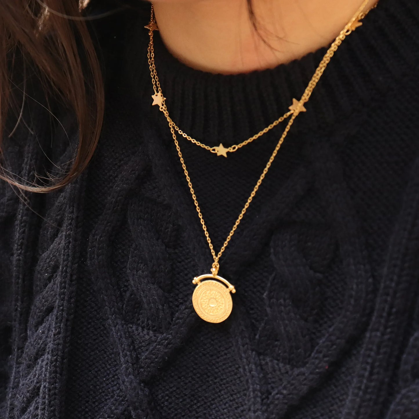 Elegant Sunbeam Gold Pendant Necklace 18K gold plated worn over black jumper, adding a touch of luxe layering and empowered style. Frequency Paris-Ibiza