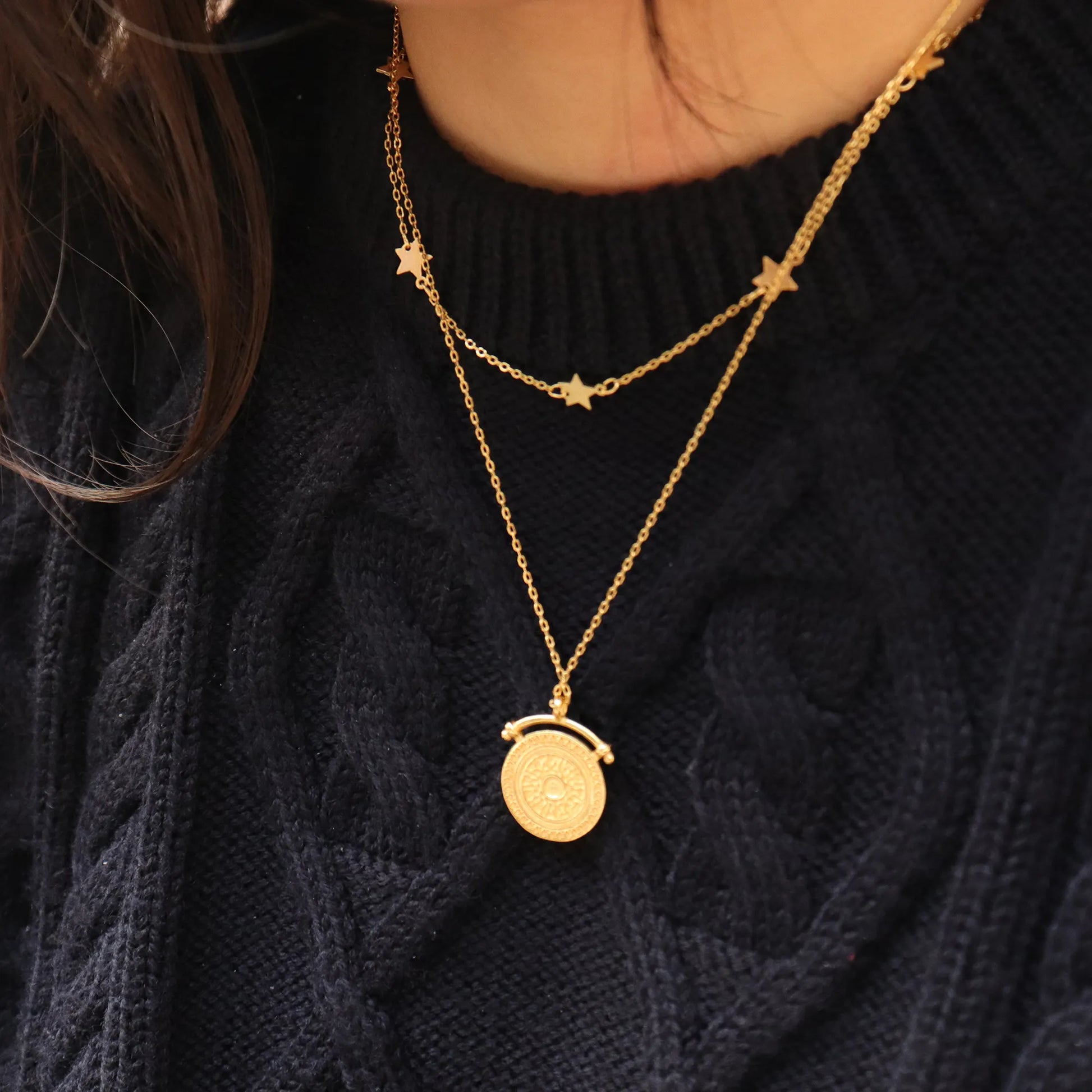 Elegant Sunbeam Gold Pendant Necklace 18K gold plated worn over black jumper, adding a touch of luxe layering and empowered style. Frequency Paris-Ibiza