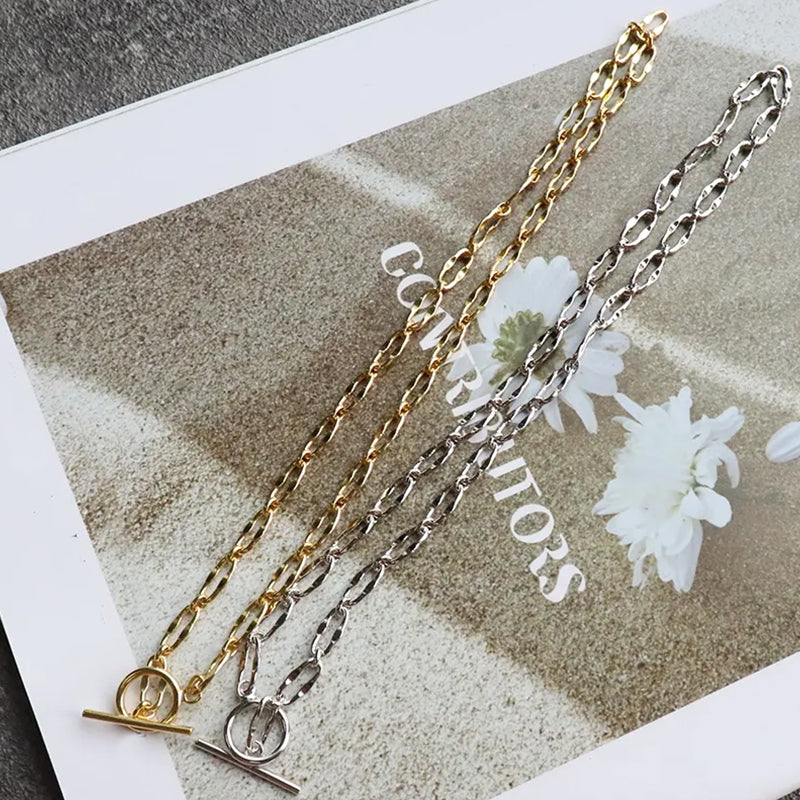 Burning Desire T-Bar chain necklace in 18k gold plated and rhodium plated sterling silver, showcasing both finishes for stacking or solo wear. Frequency Paris-Ibiza