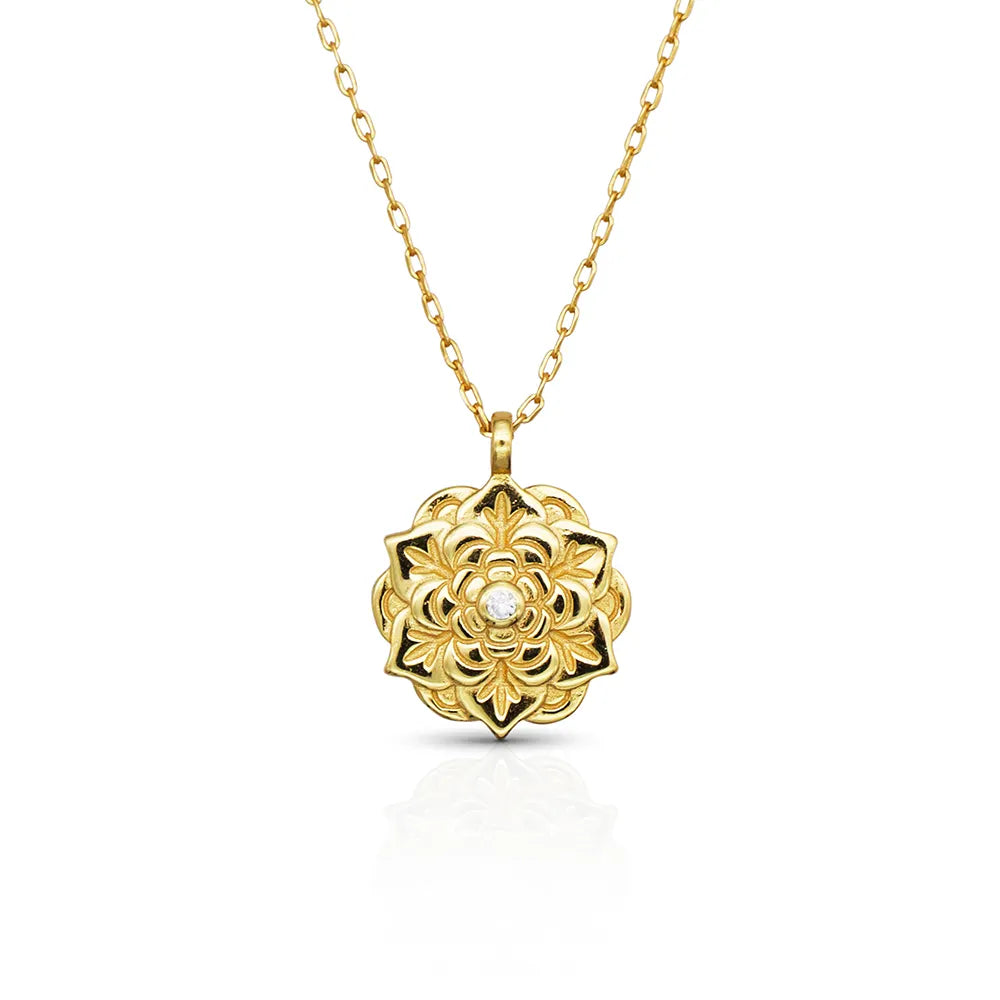 Empowerment Gold Pendant Necklace by Frequency Paris-Ibiza, on white background — floral design with central crystal on gold chain. 