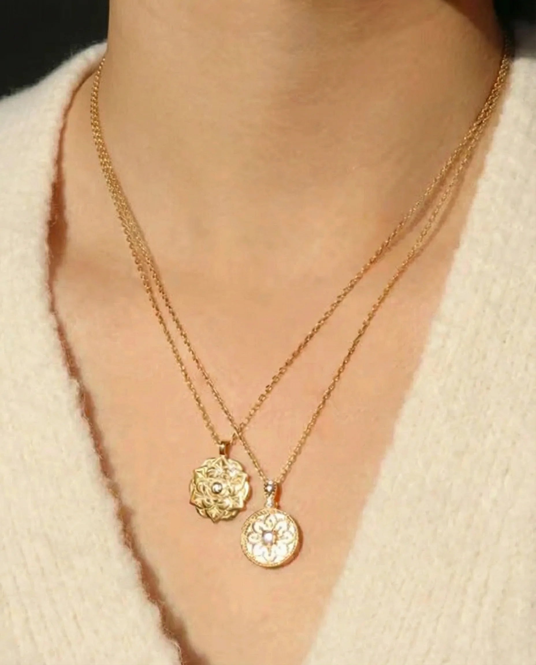 Close-up of Empowerment Gold Pendant Necklace layered with another necklace on model’s neck, highlighting floral design and central crystal. Frequency Paris-Ibiza