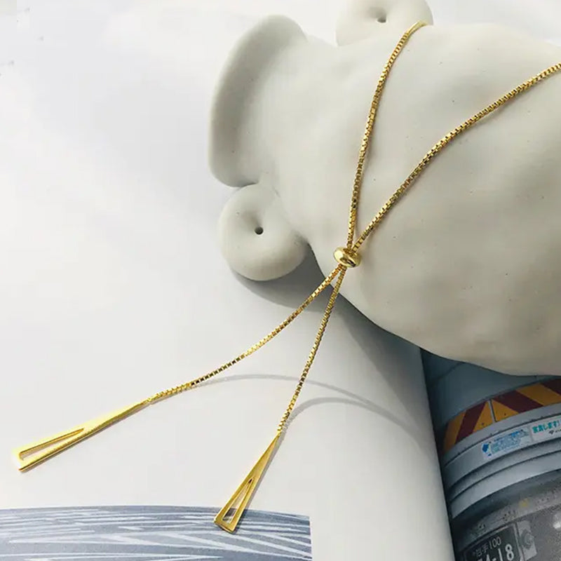 Radiance Gold Chain Necklace close-up showing central bead and adjustable geometric triangle motifs on gold chain. Frequency Paris-Ibiza