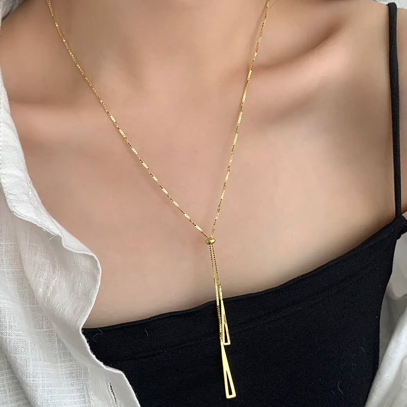 Radiance Gold Chain Necklace layered on model’s neck — geometric triangles and central bead add style and versatility. Frequency Paris-Ibiza