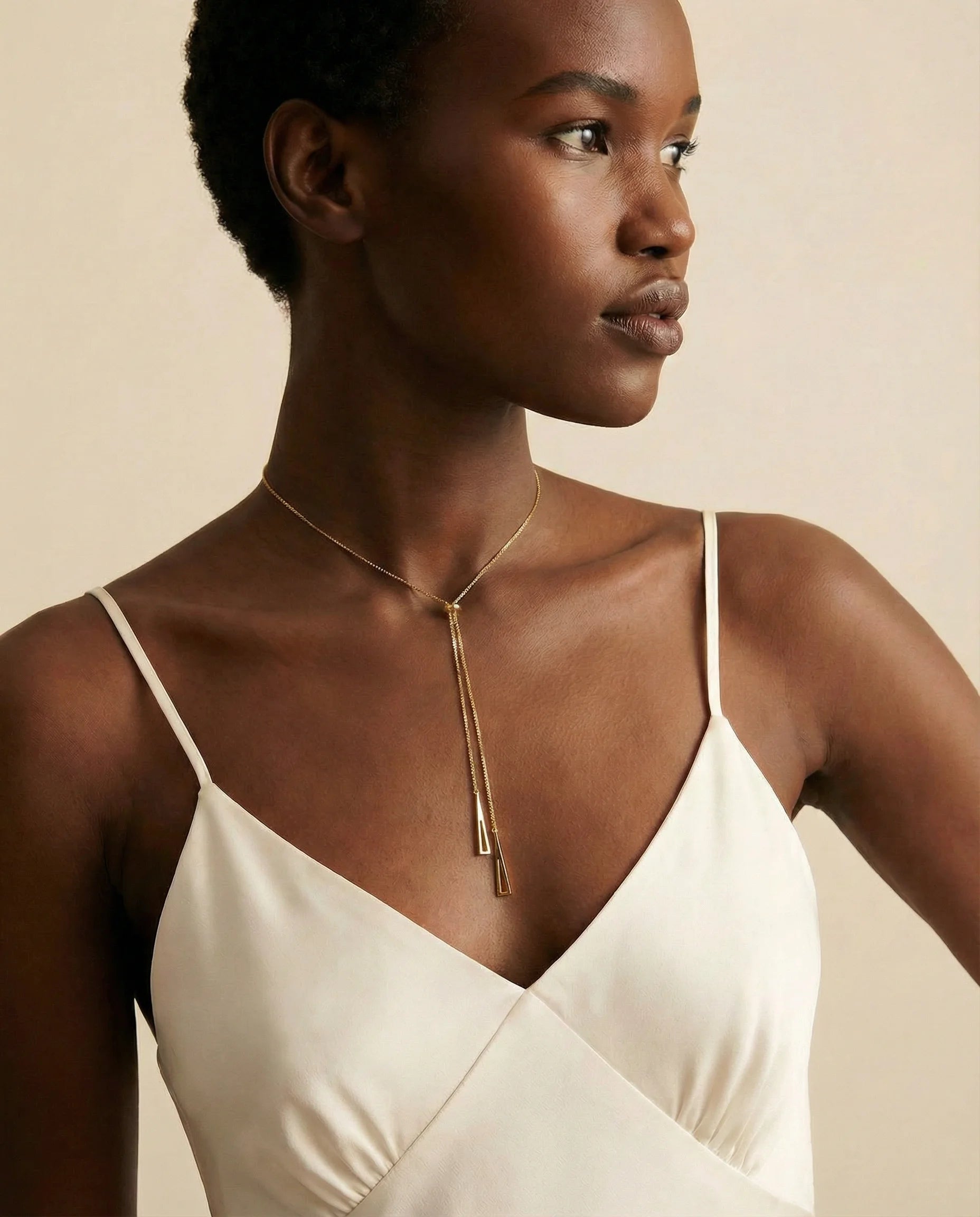 Radiance Gold Chain Necklace layered on model’s neck — geometric triangles and central bead add style and versatility. Frequency Paris-Ibiza