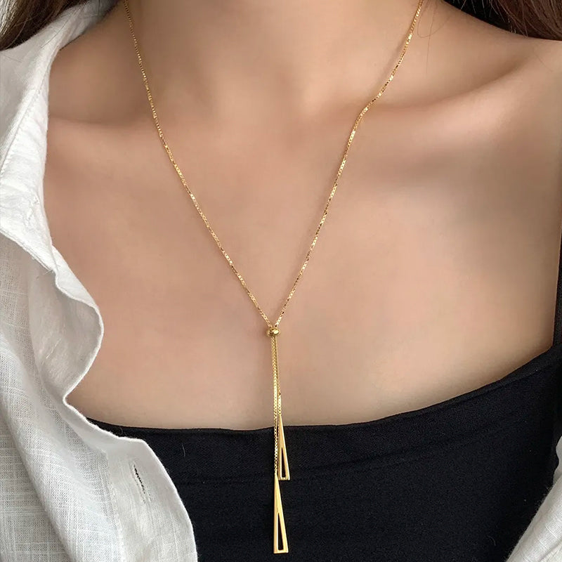 Radiance Gold Chain Necklace layered on model’s neck — geometric triangles and central bead add style and versatility. Frequency Paris-Ibiza