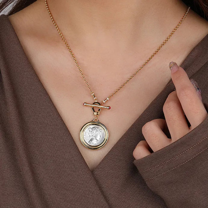 Soul Purpose Gold Pendant Necklace in silver coin finish styled on model’s neck. Frequency Paris-Ibiza