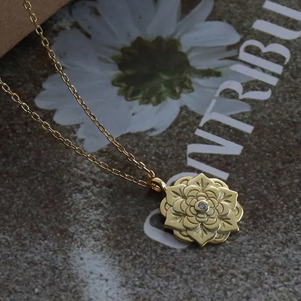 Empowerment Gold Pendant Necklace showing floral pendant with central crystal on gold chain, highlighting details and craftsmanship. Frequency Paris-Ibiza