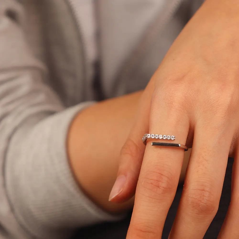Frequency Paris-Ibiza Cosmic Trust Ring in gold worn on a model, showing adjustable open band with one clean gold band and one zircon crystal encrusted band, minimal contemporary design