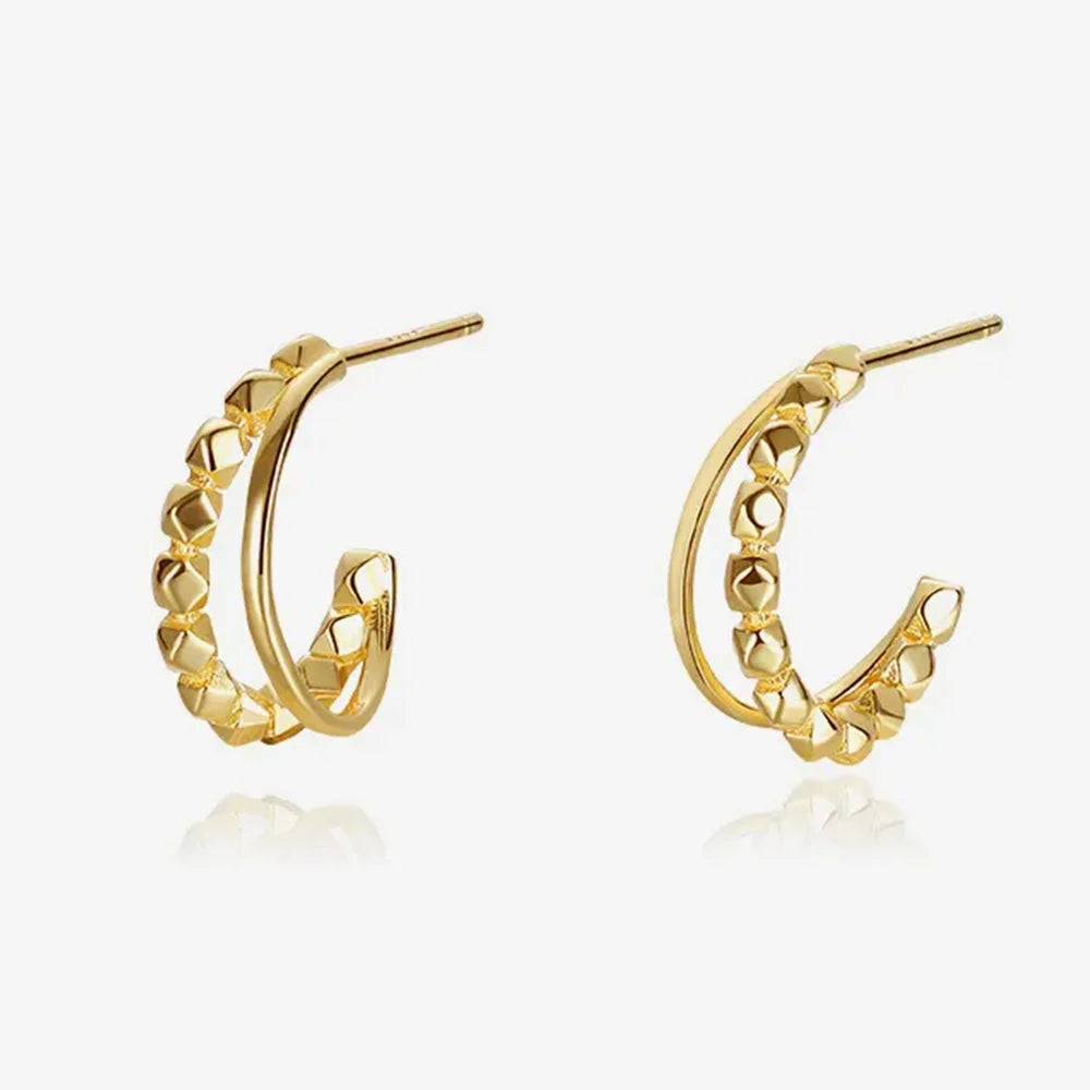 Close-up of Frequency Paris-Ibiza Divine Feminine Gold Hoop Earrings. 18K gold-plated sterling silver with one textured hoop and one smooth delicate hoop, two hoops in one design, shown on a white background.