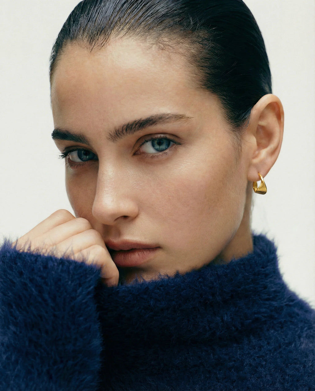 Close-up of Frequency Paris-Ibiza Eternal Wave Gold Hoop Earrings worn by model, showing sculptural swirl detail and size. Perfect gift for her.