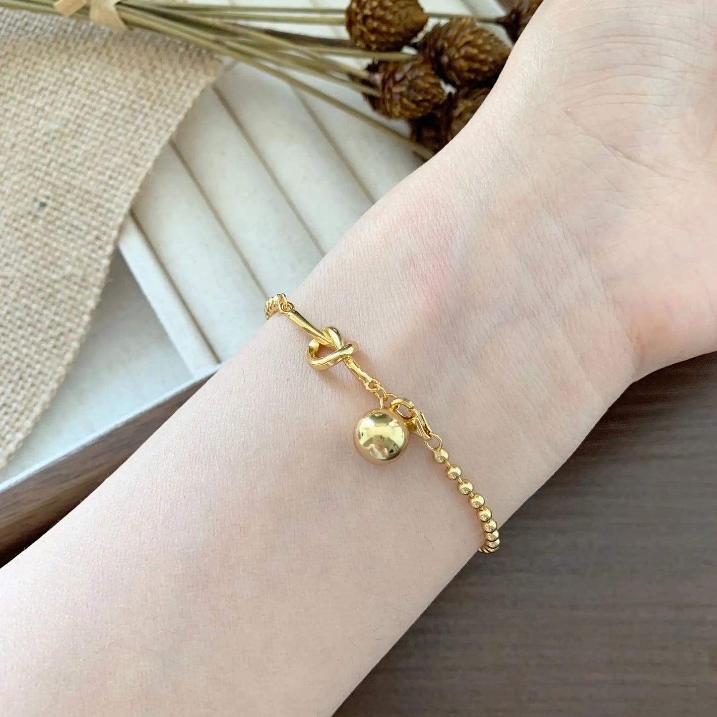 Close-up of Frequency Paris-Ibiza Gold Presence Beaded Chain Bracelet showing drop bead detail and interlocking decorative links.