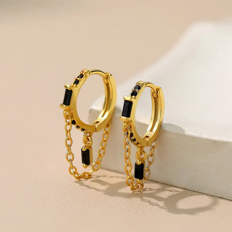 Close-up of Frequency Paris-Ibiza Infinity Huggie Earrings featuring black zircon crystals, highlighting the craftsmanship, chain hoop design, and 18k gold-plated sterling silver finish.