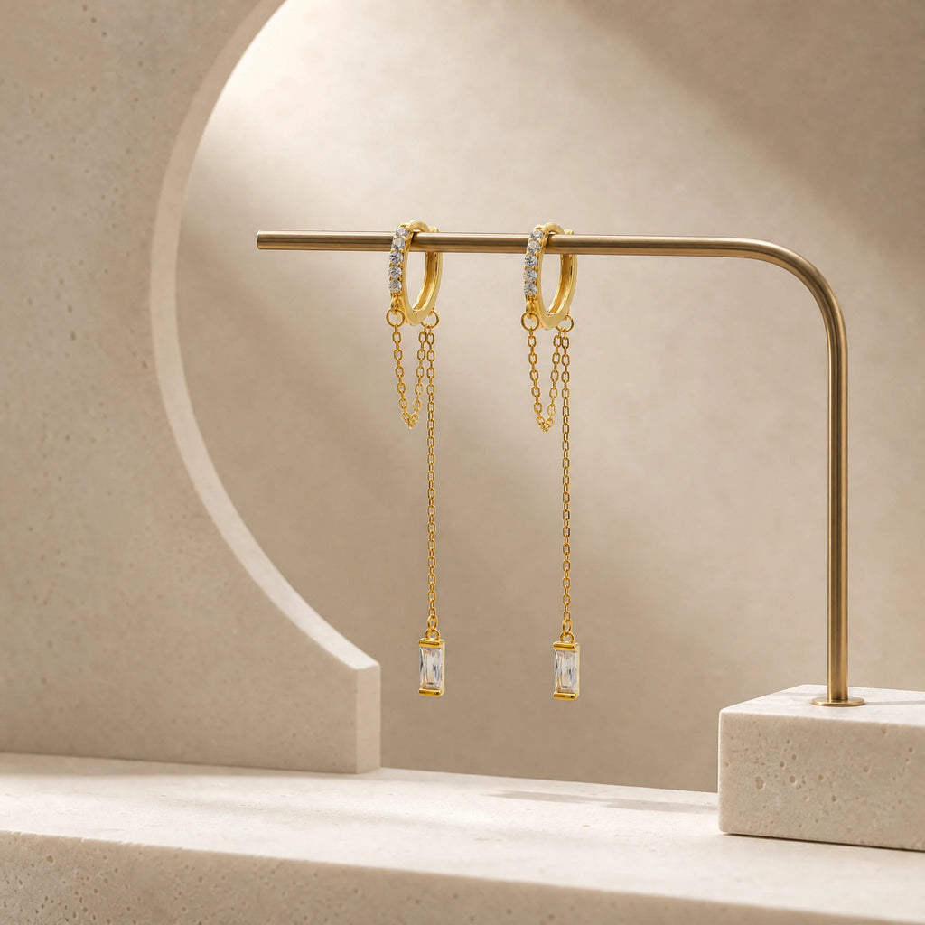 Close-up of Frequency Paris–Ibiza Infinity Chain Earrings in 18K gold, highlighting craftsmanship, zircon crystal detailing, and fine chain tassels.