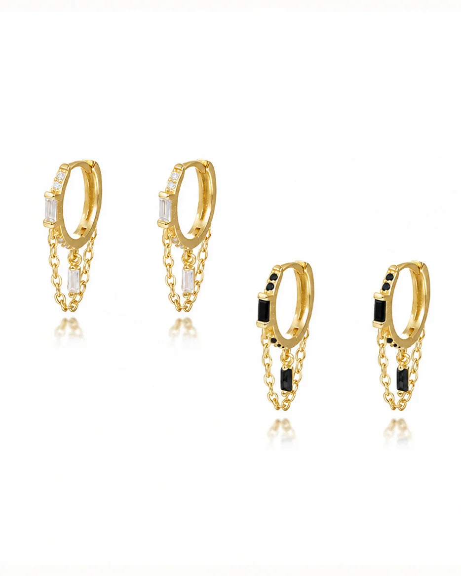 Frequency Paris-Ibiza Infinity Huggie Earrings displayed in both clear and black zircon crystal options, featuring 18k gold-plated sterling silver huggies with chain hoop detail.
