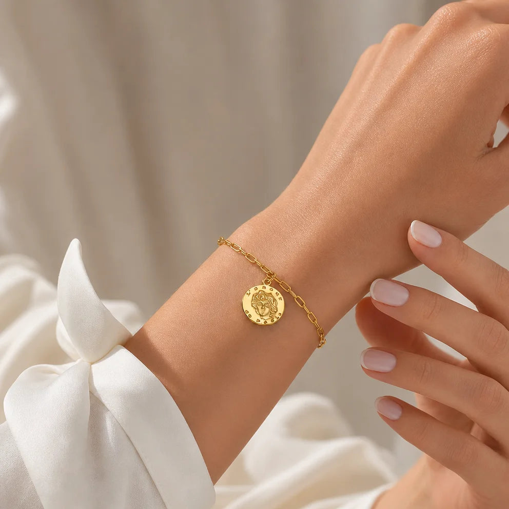 L’Amour Gold Chain bracelet with Gold Coin Charm by Frequency Paris Ibiza. Worn with a stylish white shirt. The perfect gift for her.