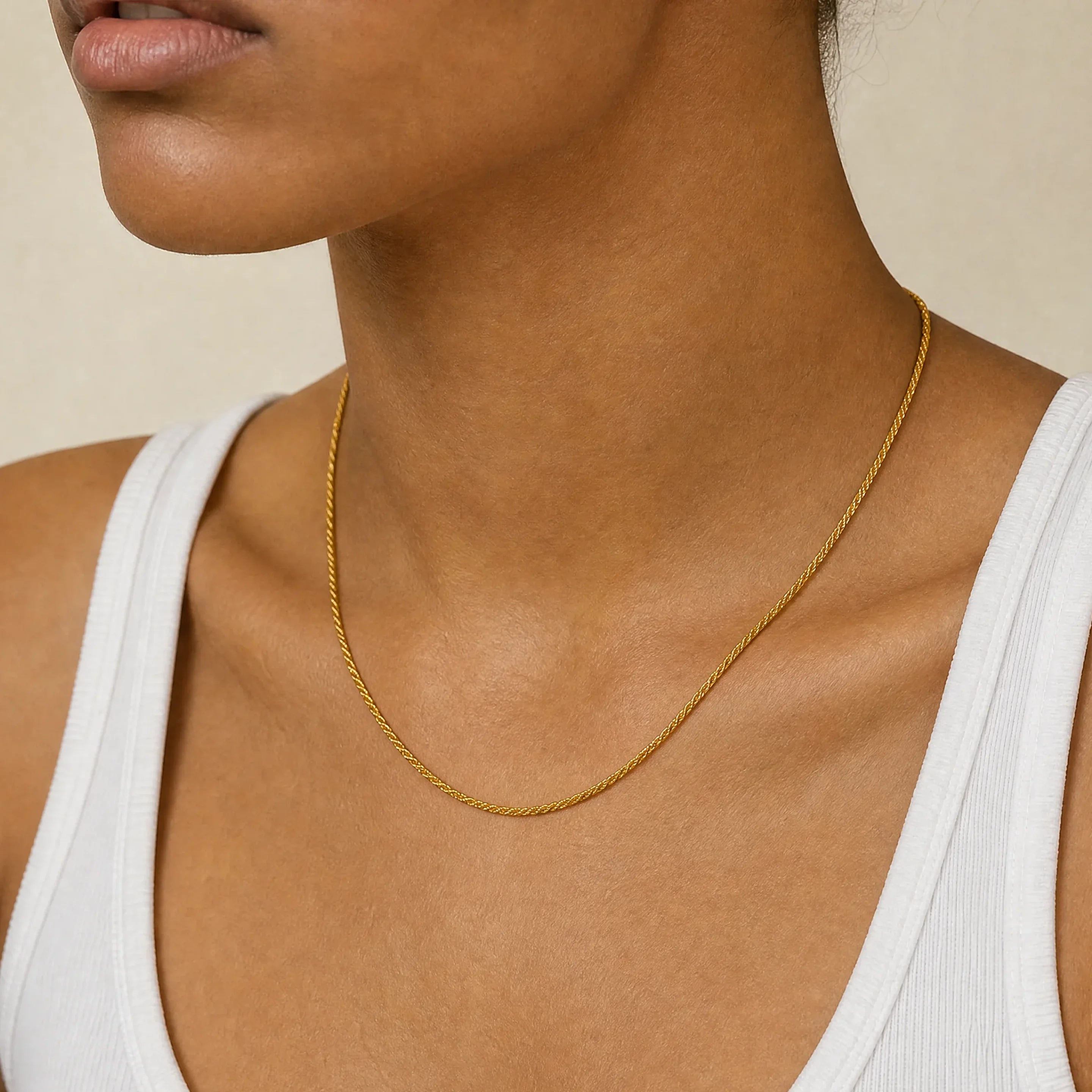 Positivity Gold Rope Chain Necklace by Frequency Paris-Ibiza stacked with a longer chain and worn with a cream blazer, adding style and sophistication to any outfit.