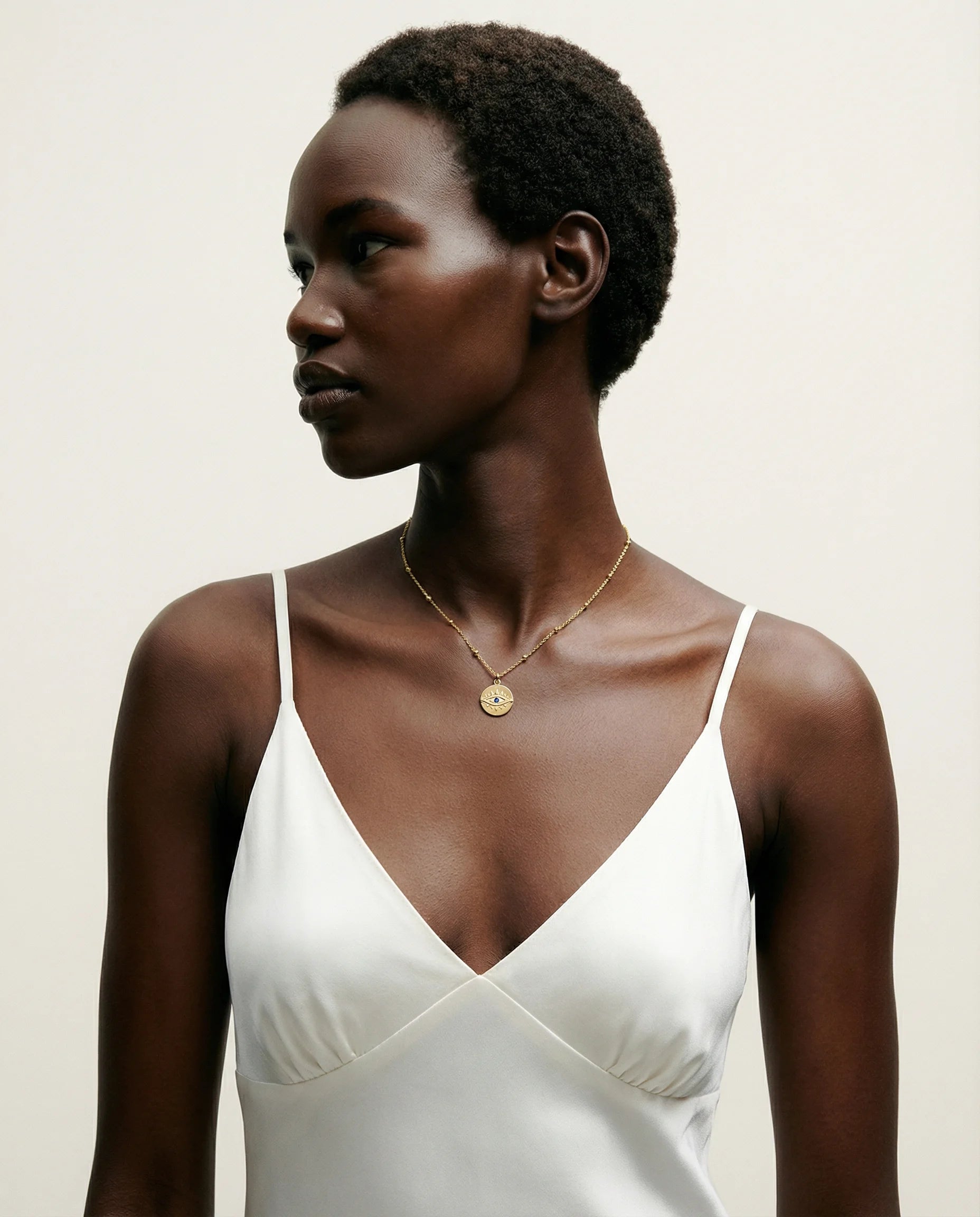 Protection Gold Pendant Necklace by Frequency Paris-Ibiza styled with a chic, minimalist slip dress, 18K gold plated sterling silver pendant as statement centrepiece. Frequency Paris-Ibiza