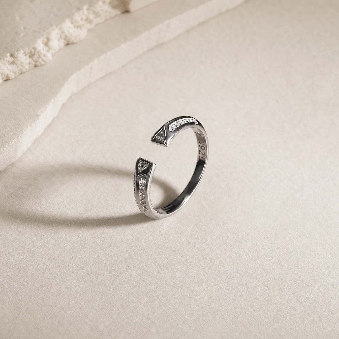 Close-up of the silver rhodium plated Frequency Paris-Ibiza Resonance Ring showing triangle crystal details and decorative crystals along the band