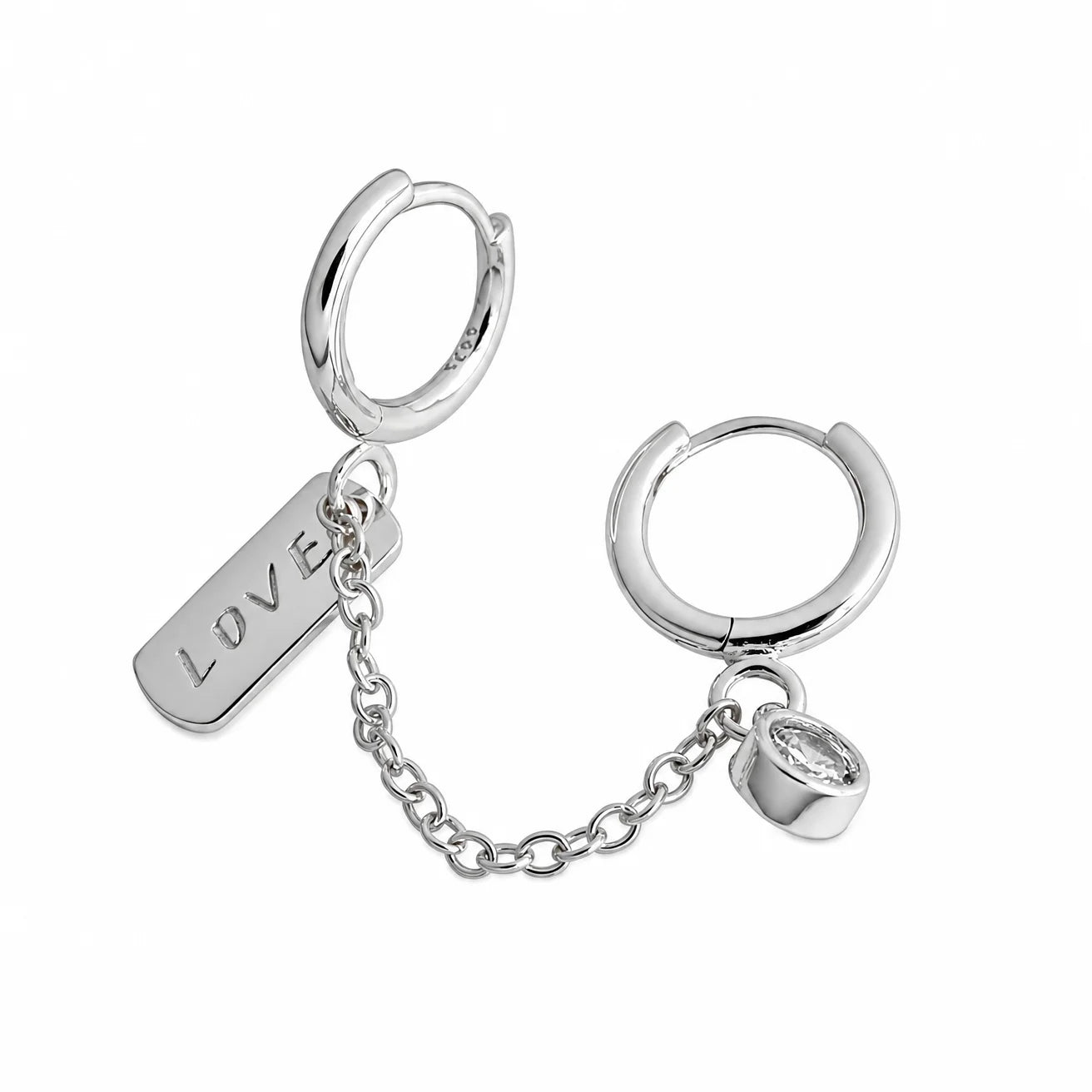 Frequency Paris-Ibiza Self Love Huggie Chain Earrings in rhodium-plated sterling silver on white background. Double huggie with chain, crystal drop gemstone, and ‘love’ tag. Perfect for day-to-night wear.