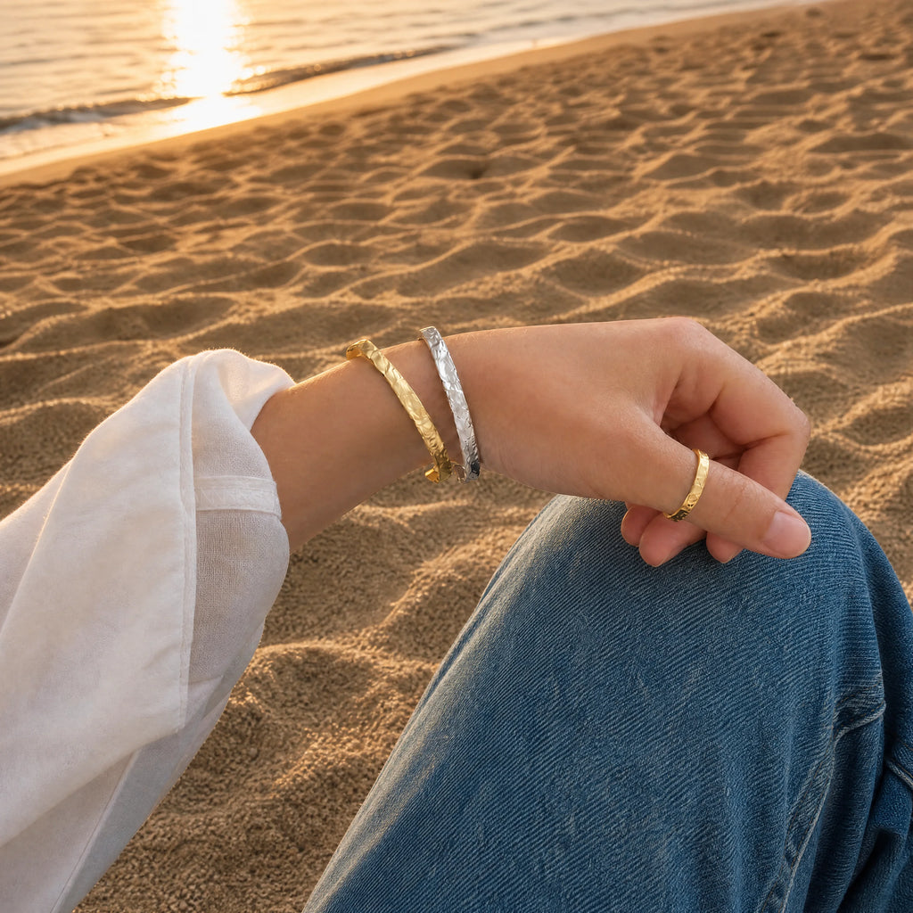 Gold and silver So Hum Cuff Bracelets by Frequency Paris-Ibiza worn together for a mixed metal look.