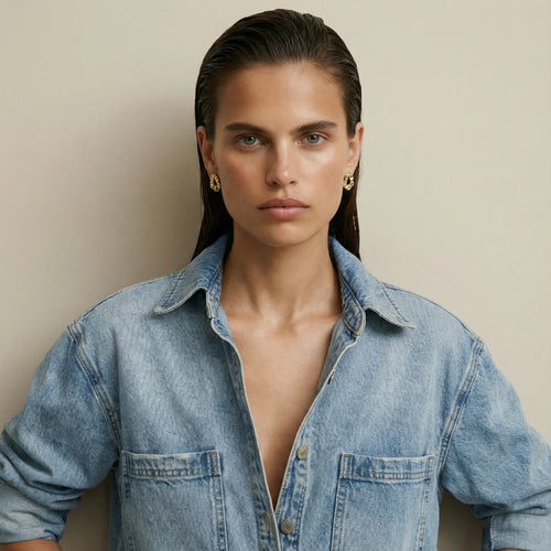 Brilliance stud earrings in 18k gold-plated sterling silver by Frequency Paris-Ibiza, worn with a cool denim shirt for an elegant, refined look.