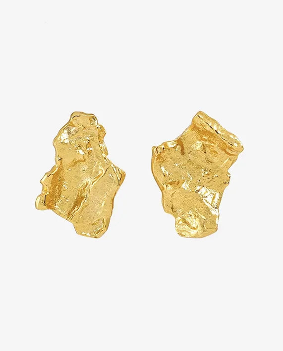 Close-up of hand-crafted 18k gold-plated sterling silver Grounding earrings with hammered, irregular design. Organic texture that celebrates the beauty of imperfect forms. Frequency Paris-Ibiza.