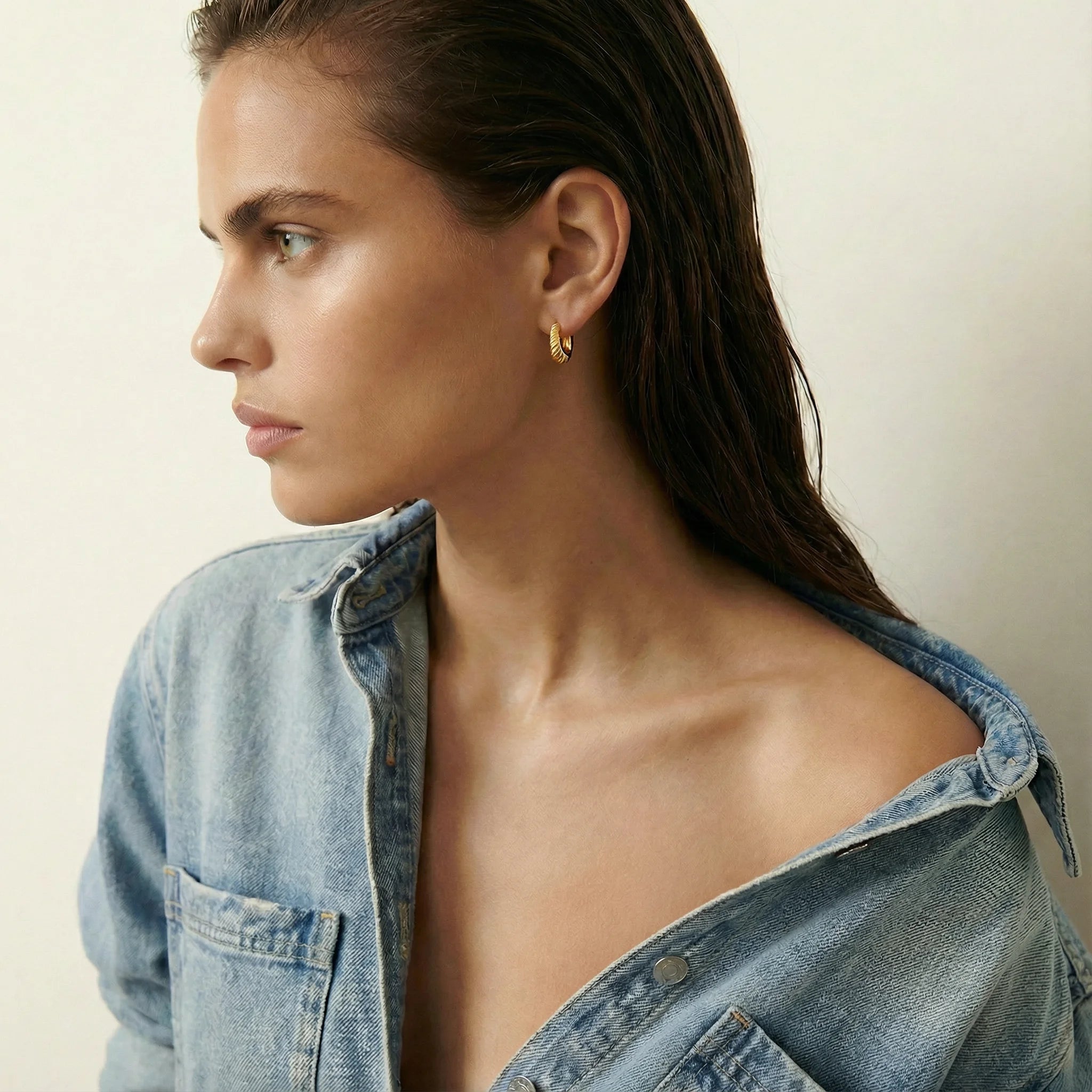 Profile shot of a model wearing the Costes Gold Hoop Earrings by Frequency Paris-Ibiza, sophisticated for day-to-night wear.