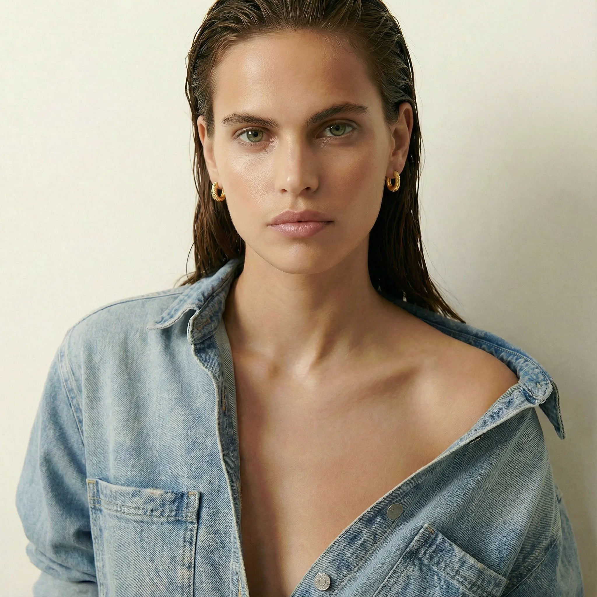 Costes Gold Hoop Earrings by Frequency Paris-Ibiza worn on a model with a denim shirt, effortless, chic, and cool.