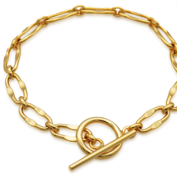 Flat lay of Frequency Paris-Ibiza Burning Desire gold T-bar bracelet on white background