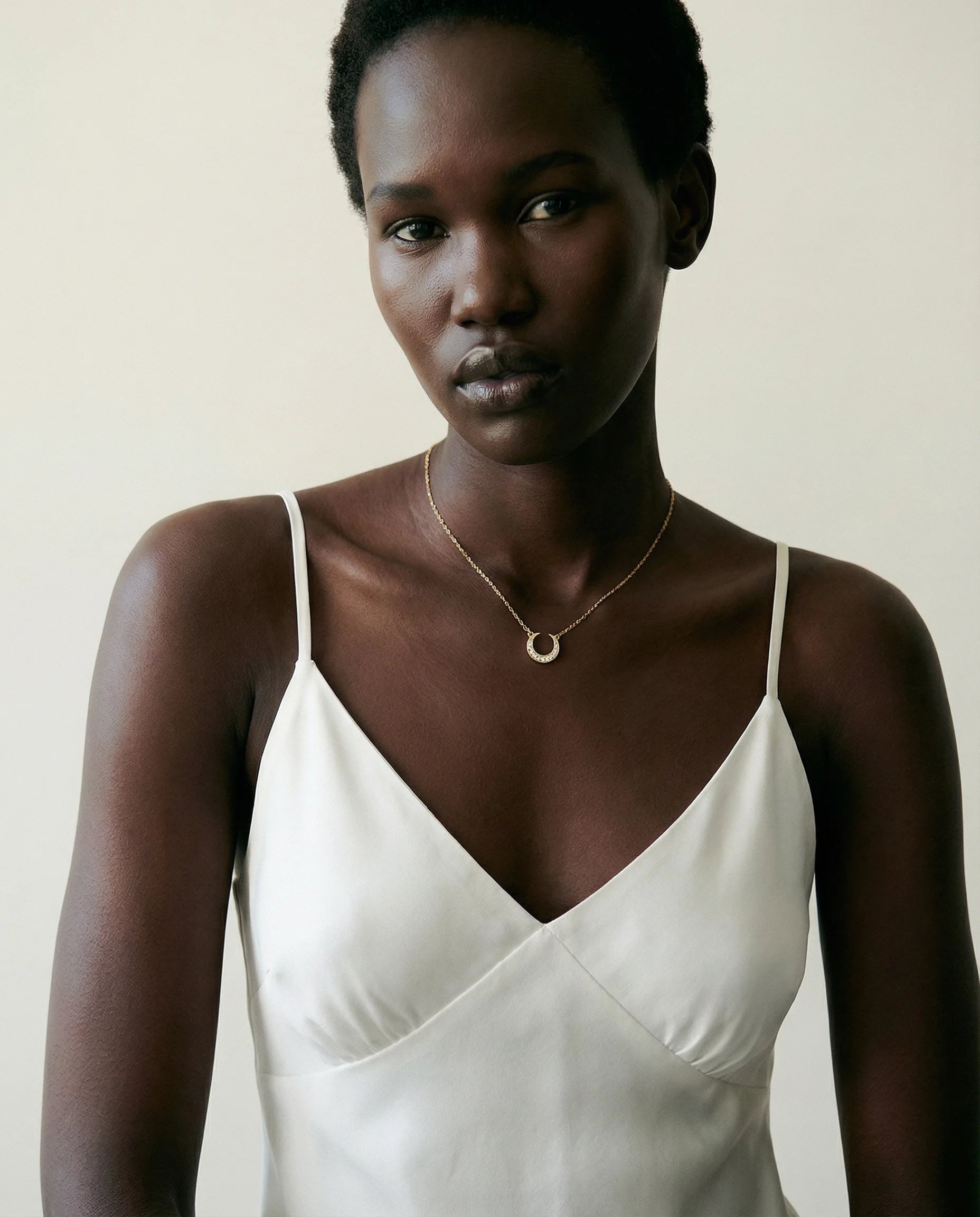 Dreamscape Gold Pendant Necklace by Frequency Paris-Ibiza — worn on model, showcasing delicate celestial crescent moon design with sparkling zircon crystals.