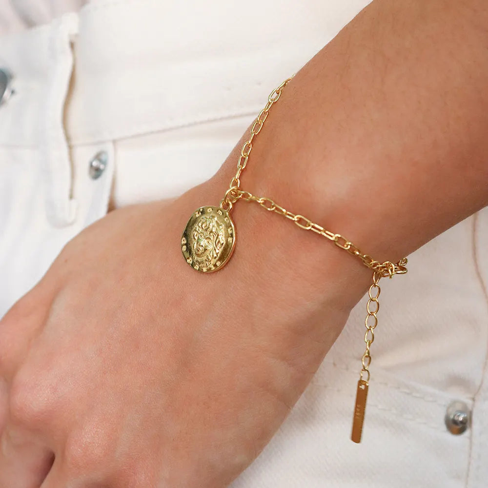 Frequency Paris-Ibiza L'Amour Gold Chain Bracelet on wrist with close-up of coin charm featuring face and L'Amour de Paris text