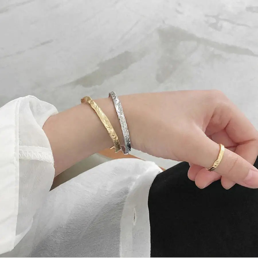 Gold and silver So Hum Cuff Bracelets by Frequency Paris-Ibiza worn together for a mixed metal look.
