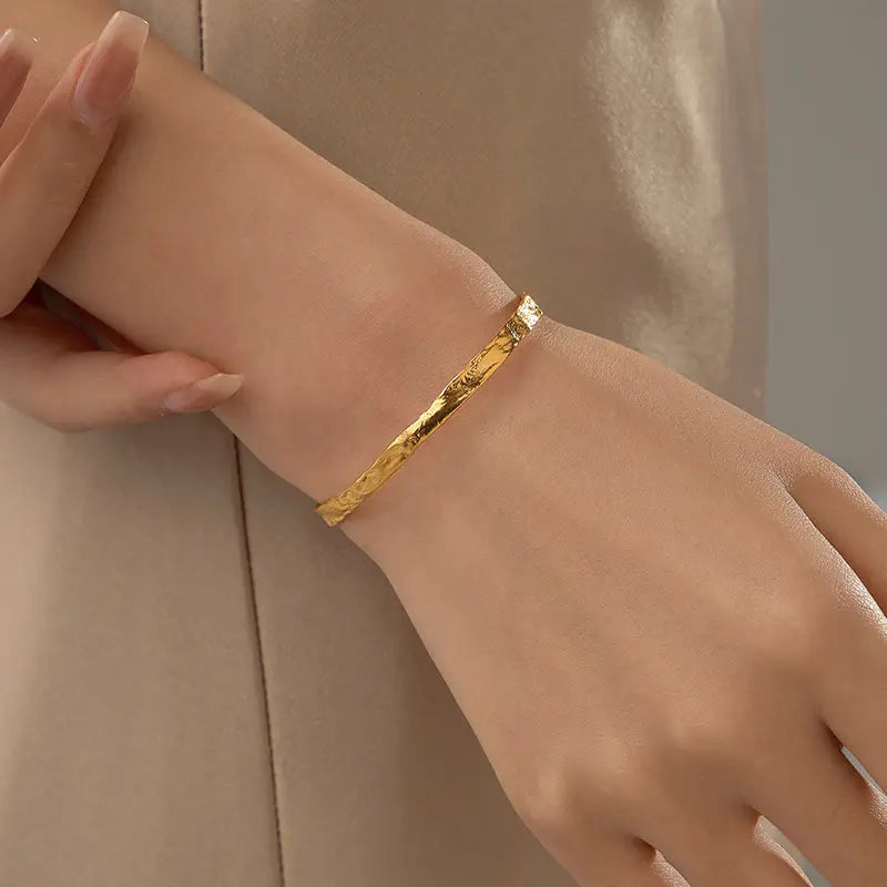 Frequency Paris-Ibiza So Hum gold cuff bracelet worn on delicate wrist, radiating elegant simplicity