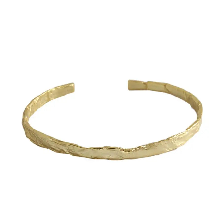 Frequency Paris-Ibiza So Hum gold cuff bracelet on white background showing minimalist hammered design