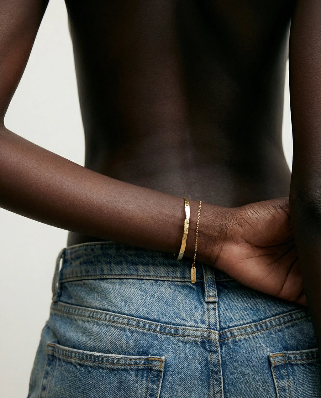 Frequency Paris-Ibiza So Hum gold cuff bracelet worn with faded blue boyfriend jeans for polished, luxe bohemian style
