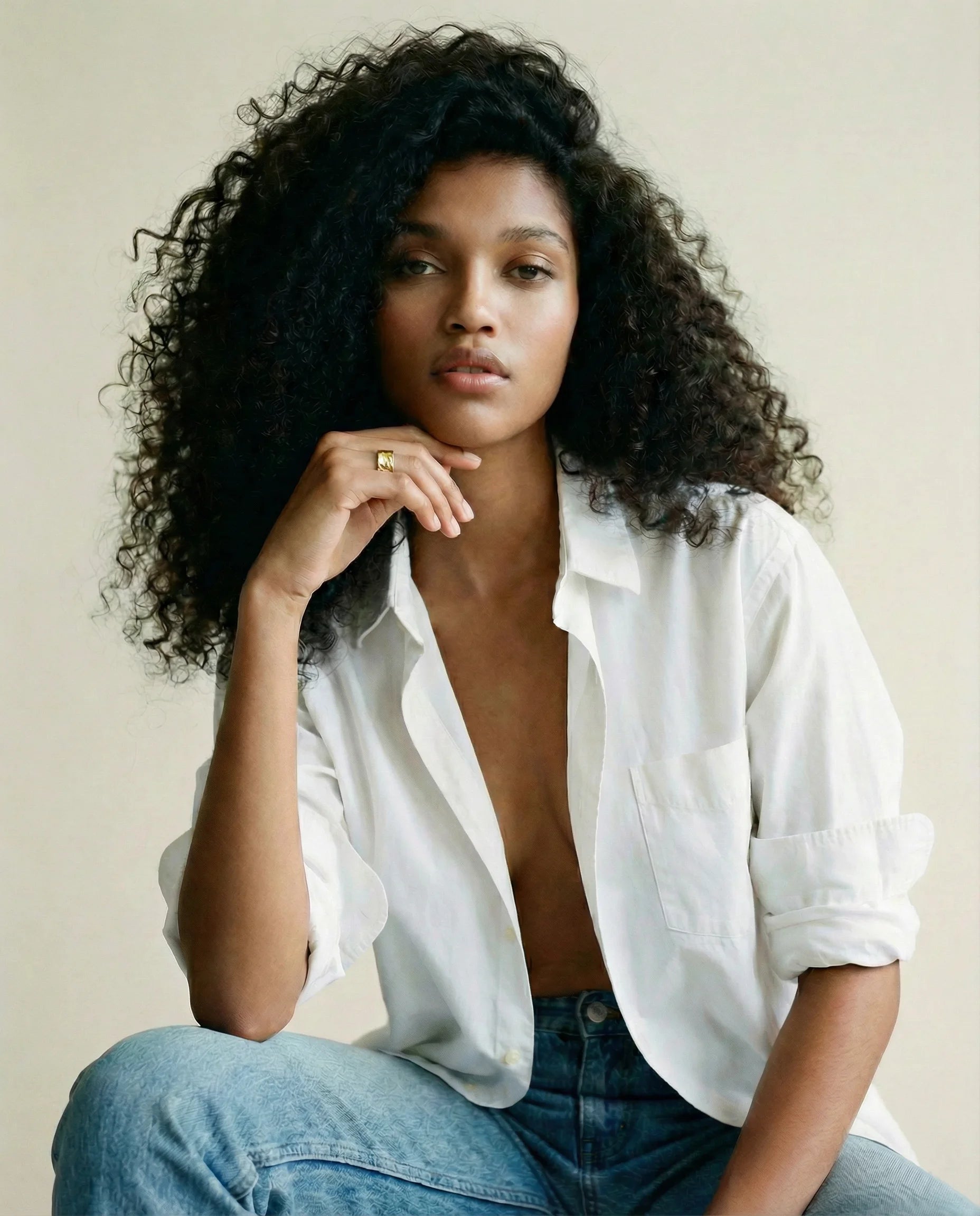 Gaia Ring by Frequency Paris-Ibiza worn on a model in an open white shirt and blue jeans, embodying effortless, modern style. The 18k gold-plated ring’s organic design brings a natural, grounded energy to the outfit.