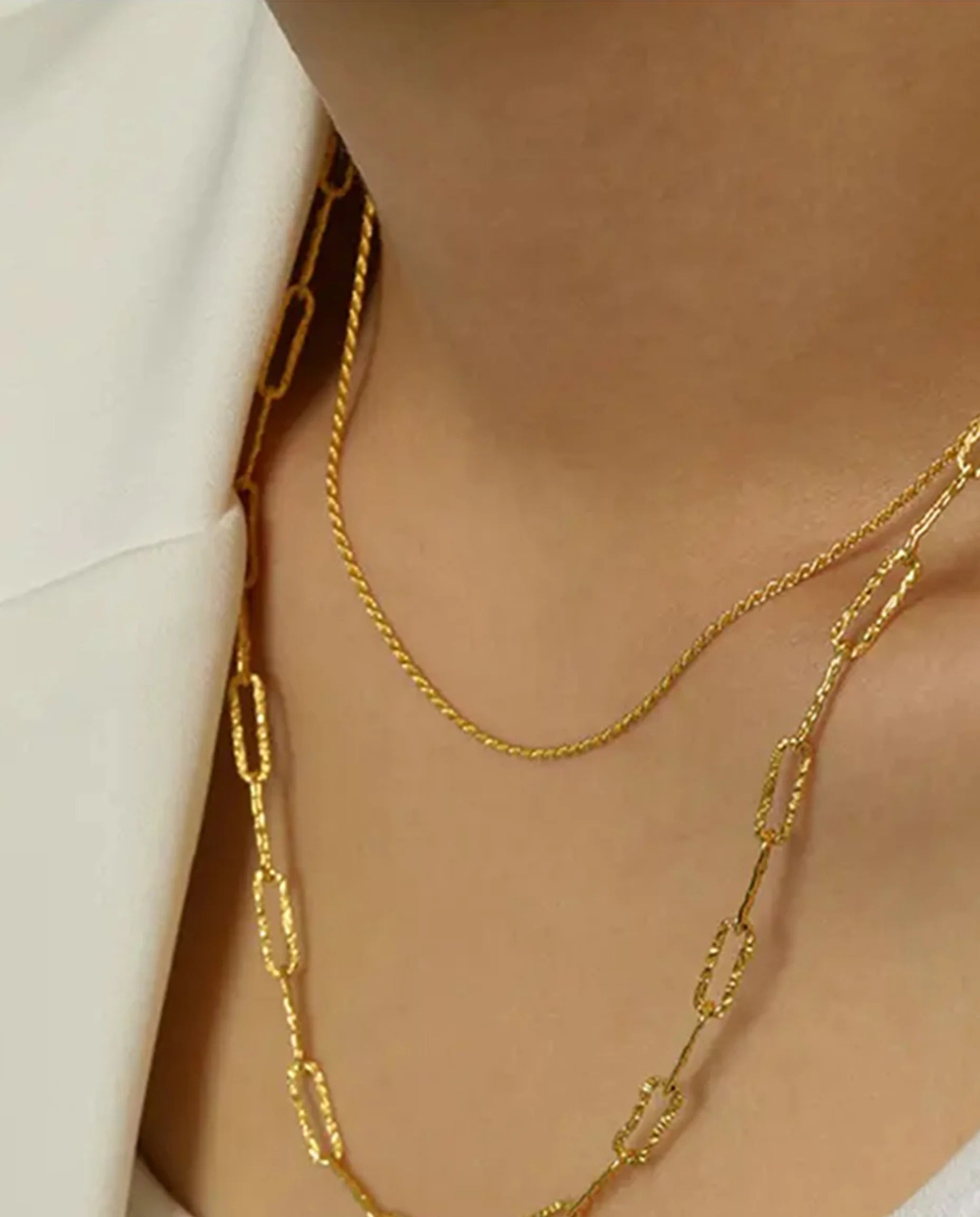 Positivity Gold Rope Chain Necklace by Frequency Paris-Ibiza stacked with a longer chain and worn with a cream blazer, adding style and sophistication to any outfit.