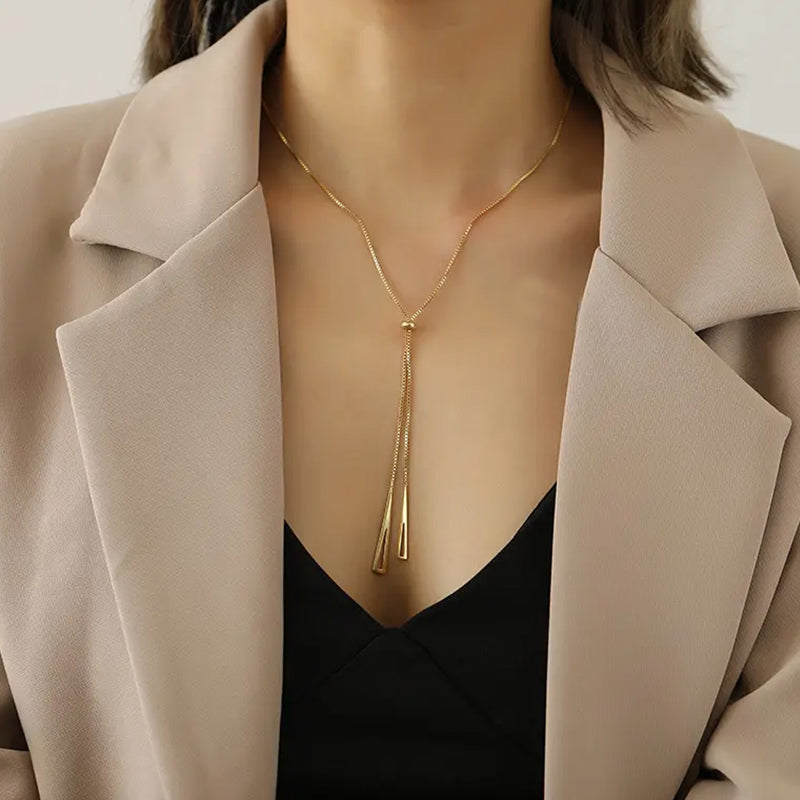 Radiance Gold Chain Necklace close-up on model’s neck styled with a blazer— adjustable gold chain with triangle motifs and central bead. Frequency Paris-Ibiza